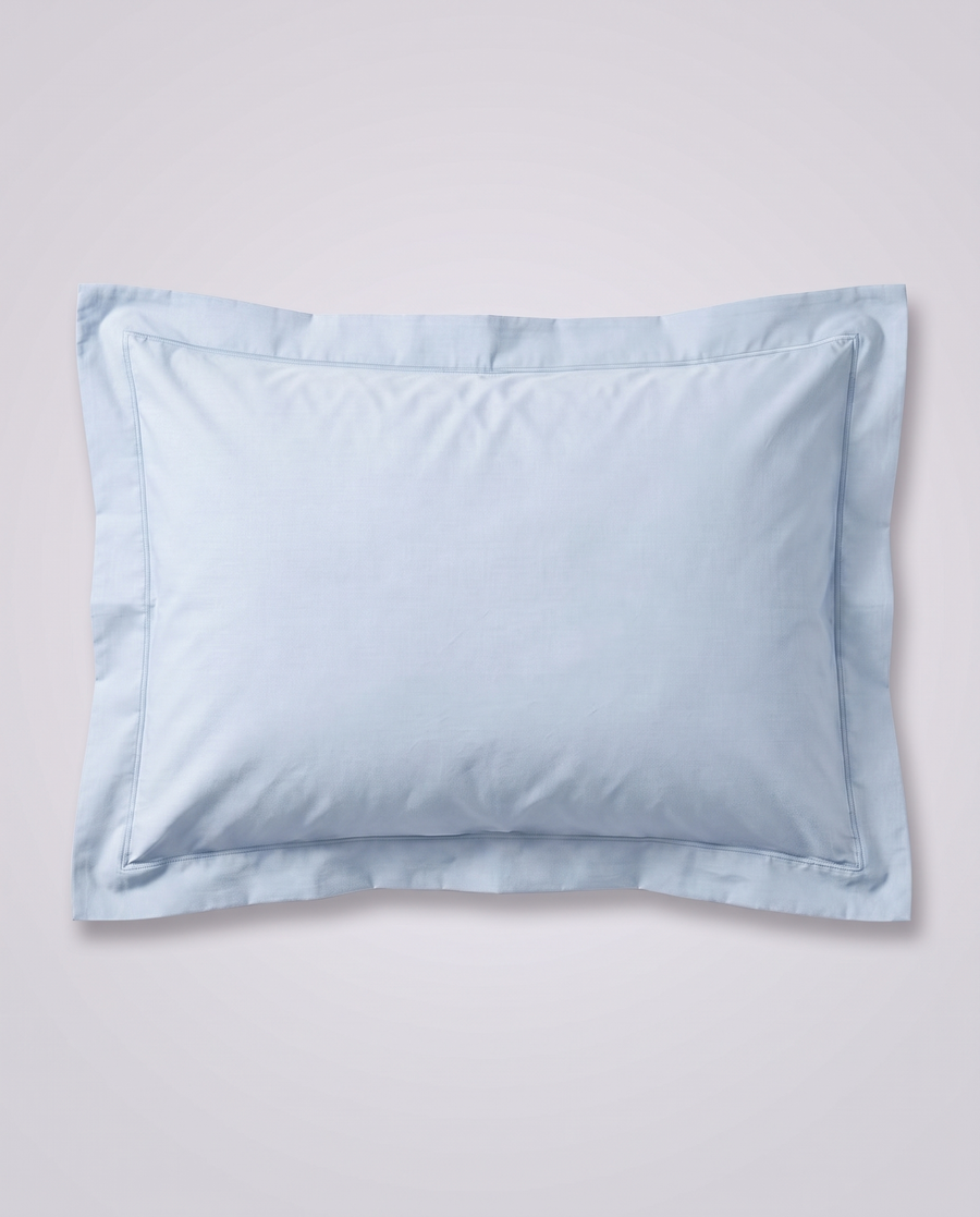 Taie d’oreiller en percale bleu ciel personnalisable par broderie, à plat, sur fond gris studio